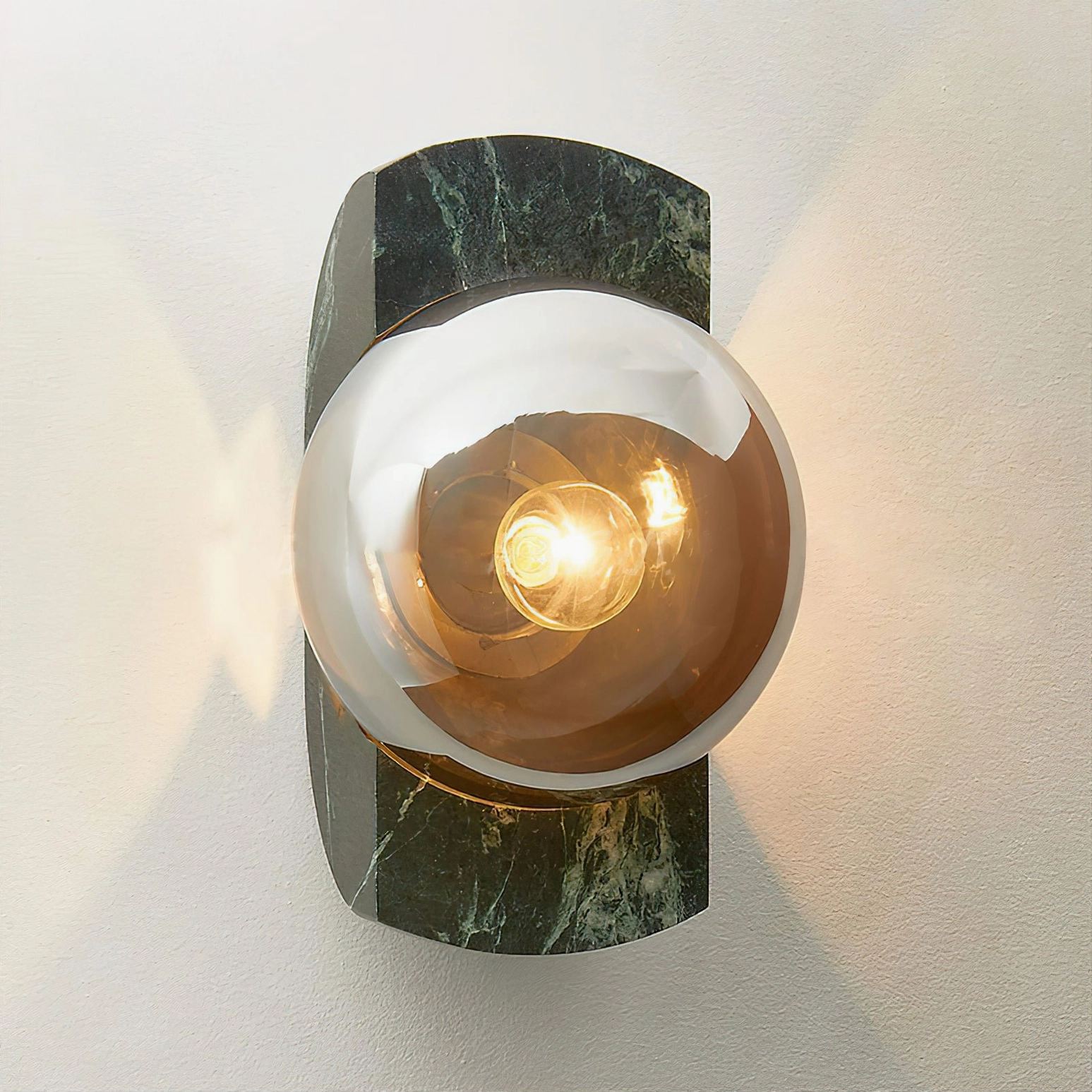 Neptune wall sconce illuminated with warm bulb, smoked amber glass shade detail