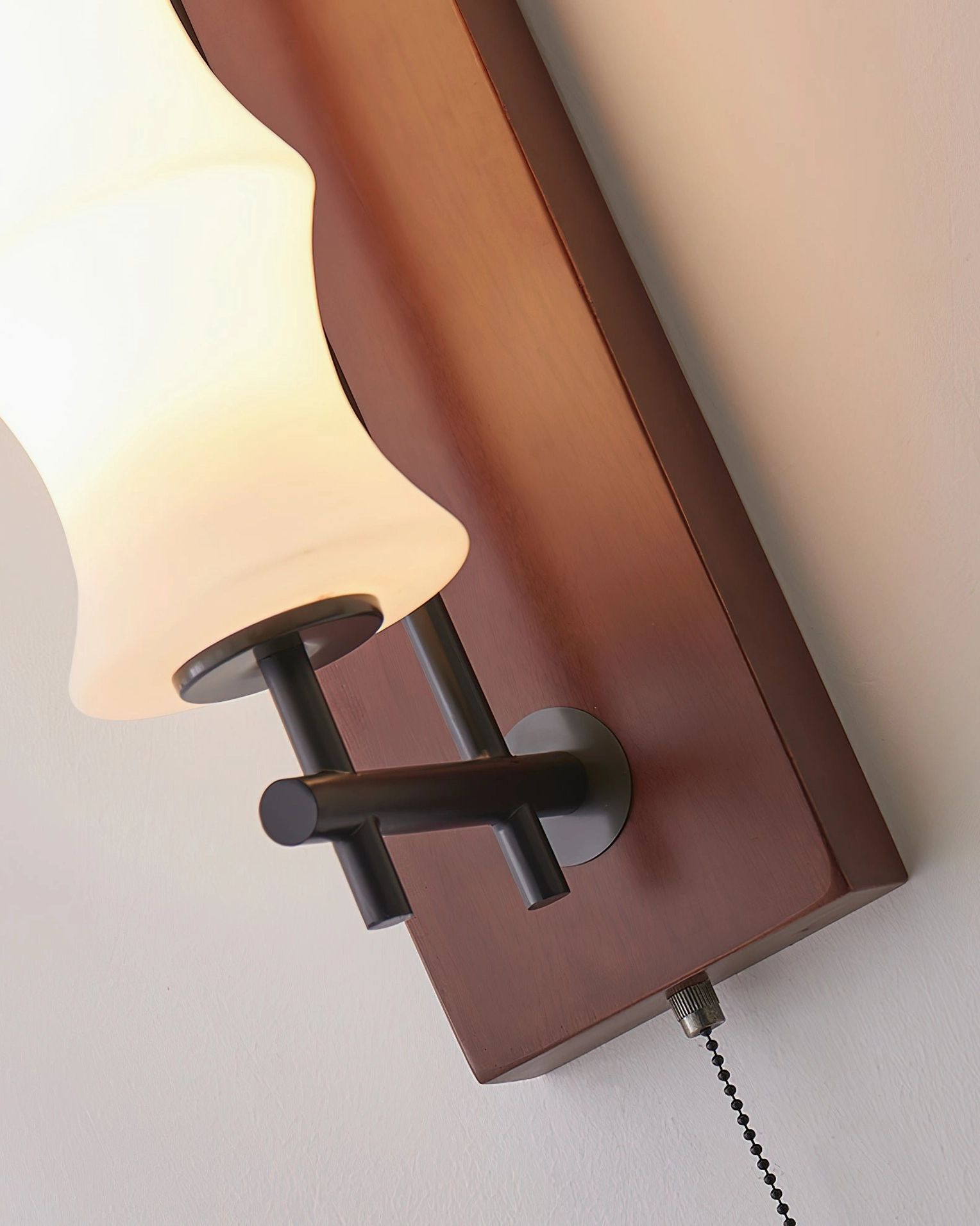 Nesta mid-century modern wall sconce in contemporary interior, wood finish with warm ambient lighting effect
