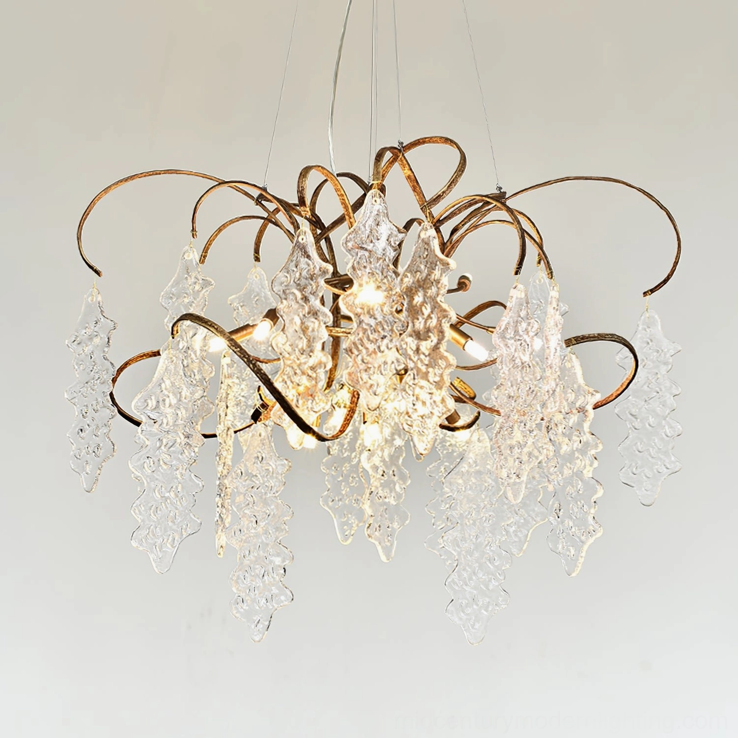 Niagara Chandelier detail view showing curved brass metalwork and clear glass ornaments on light background