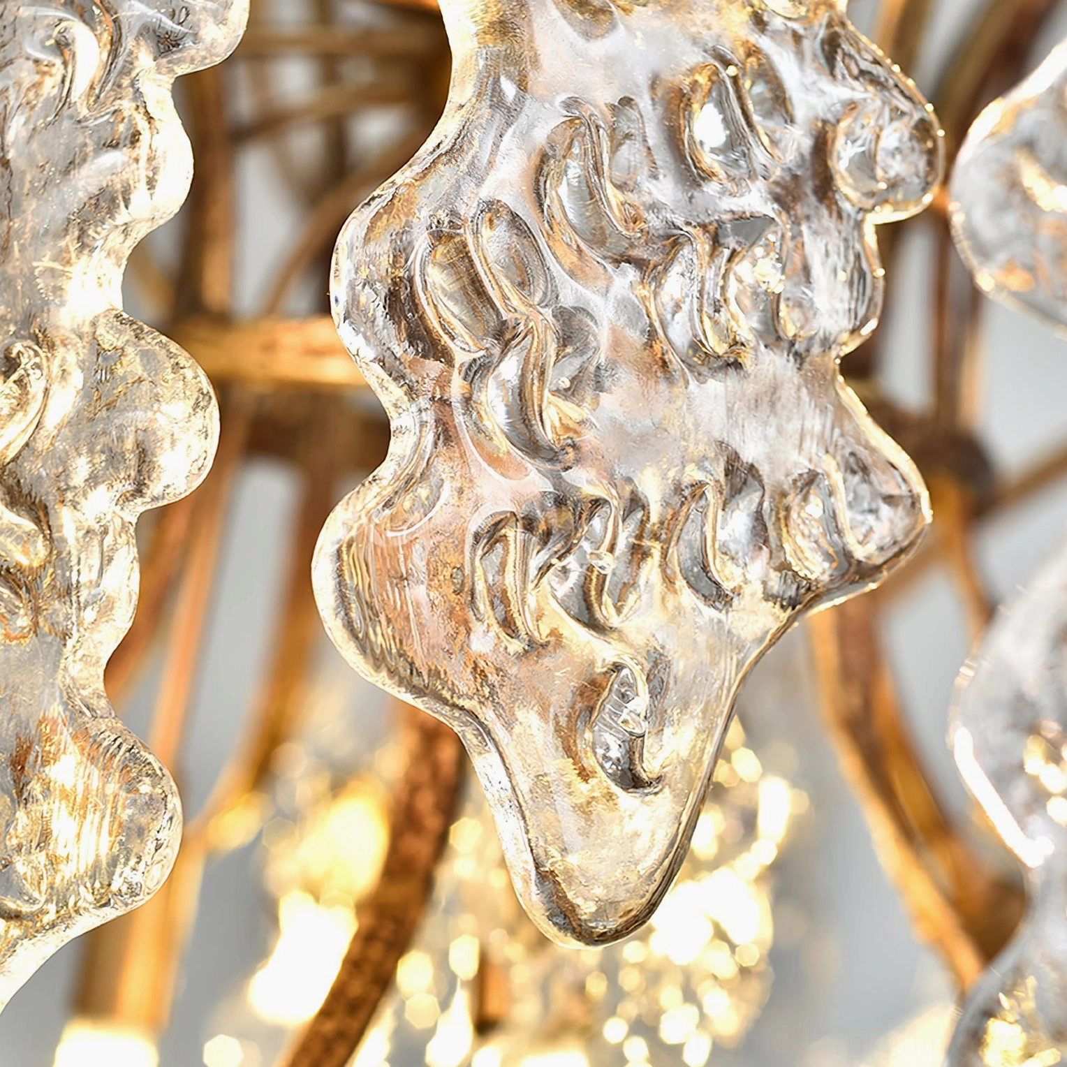 Niagara Round Chandelier with clear glass elements and aged brass finish on neutral background