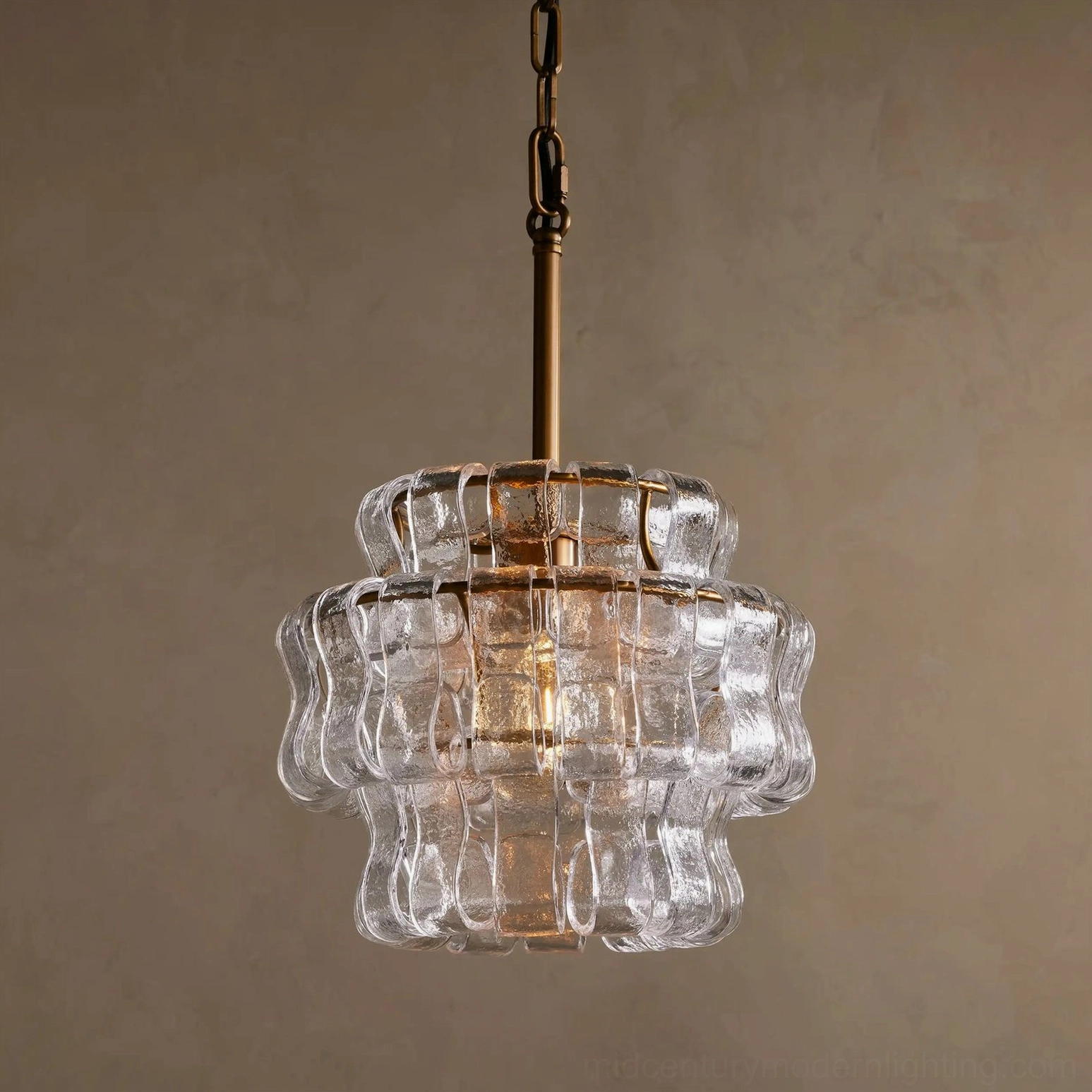 Illuminated Nirsa pendant with clear rippled glass creating soft warm golden glow