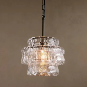 Illuminated Nirsa pendant light with soft golden glow through rippled glass, interior setting