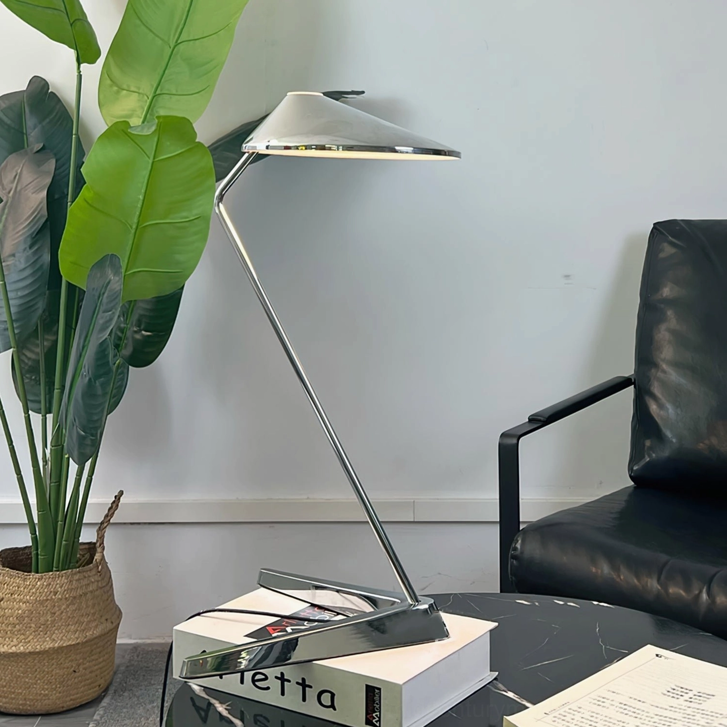 Modern chrome table lamp three-quarter view potted plant leather chair