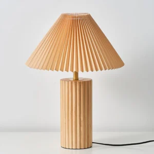 Nora table lamp close-up detail showing brass connector, pleated khaki fabric shade, and electrical cord