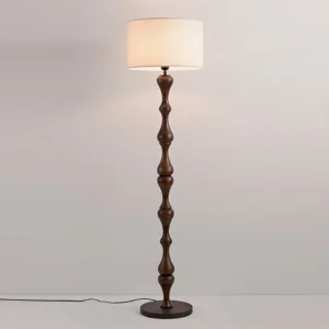 Norden mid-century modern floor lamp walnut color with sculptured wooden pole on neutral background