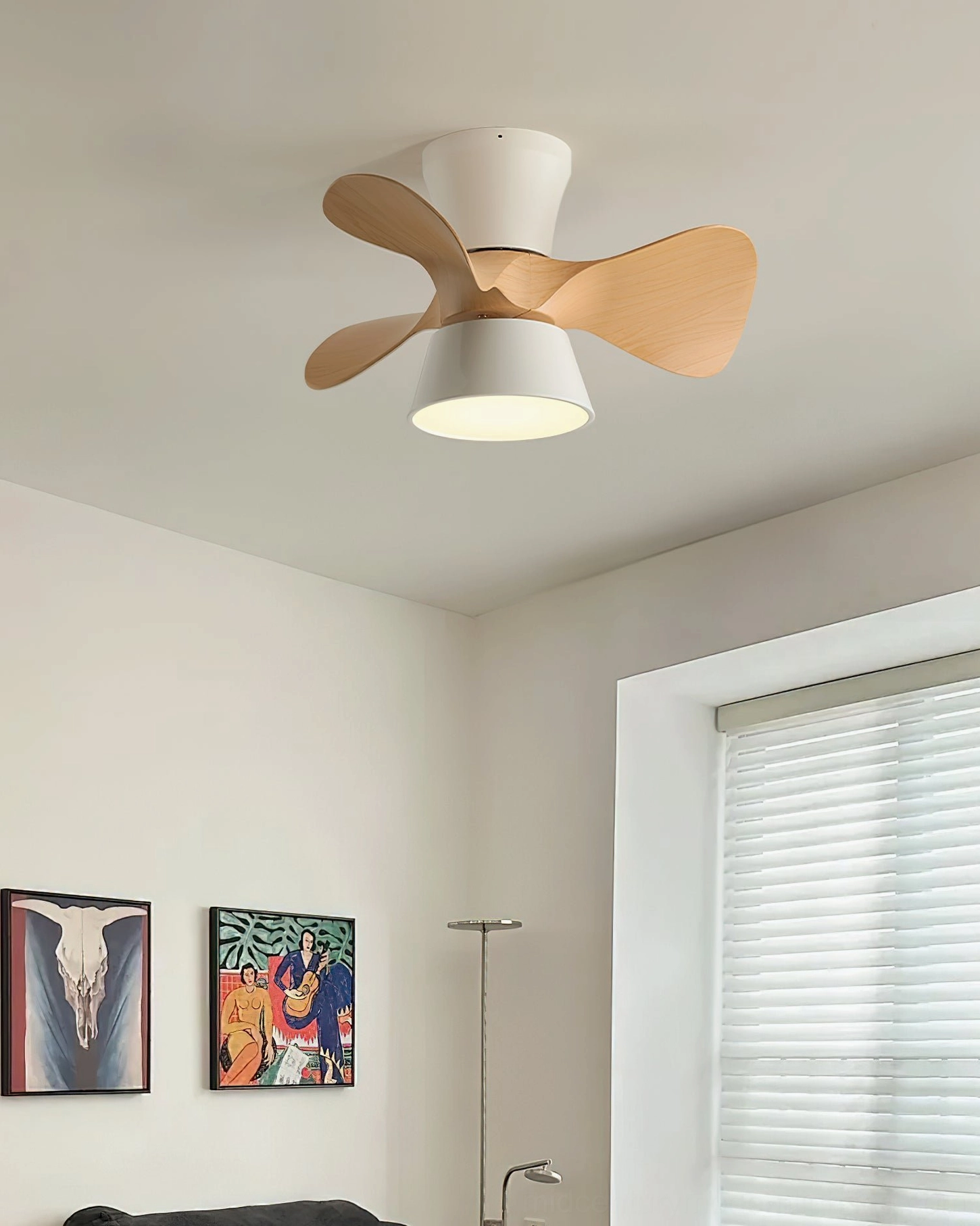 Minimalist DC ceiling fan with integrated LED light in living room corner, displaying wood finish blades and modern white housing