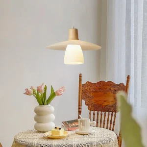 Scandinavian pendant light illuminating a vintage dining nook with warm japandi design aesthetic