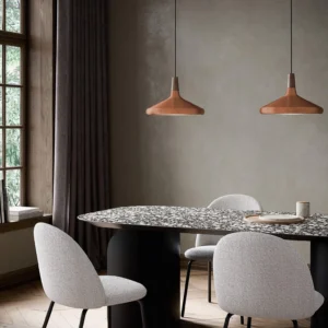 Three copper rose gold Nori pendant lamps hanging over luxury dining table with upholstered chairs, scandinavian interior design
