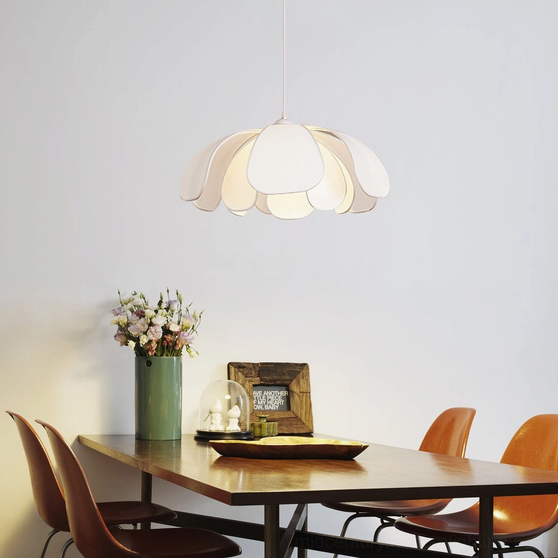 Norm white petal pendant lamp overhead view warm dining room with wooden table setting