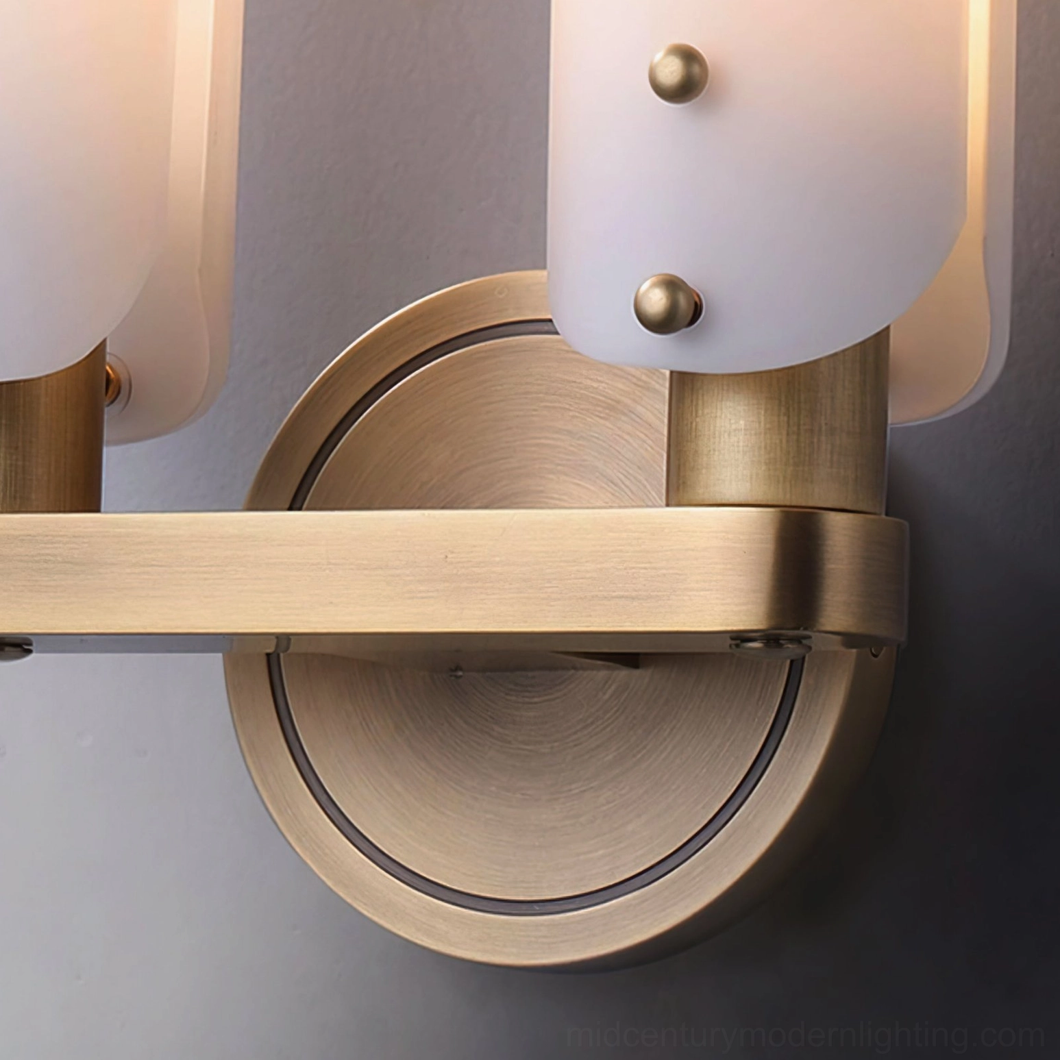 Brushed brass metal construction detail of Norwalk wall sconce with exposed mounting hardware