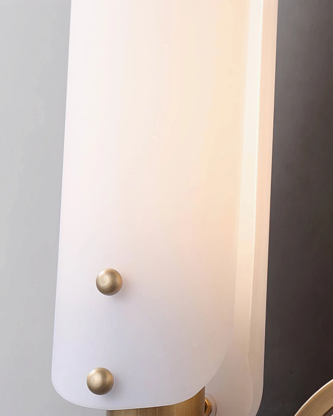 Close-up detail of frosted white glass shade on Norwalk sconce with brass decorative hardware