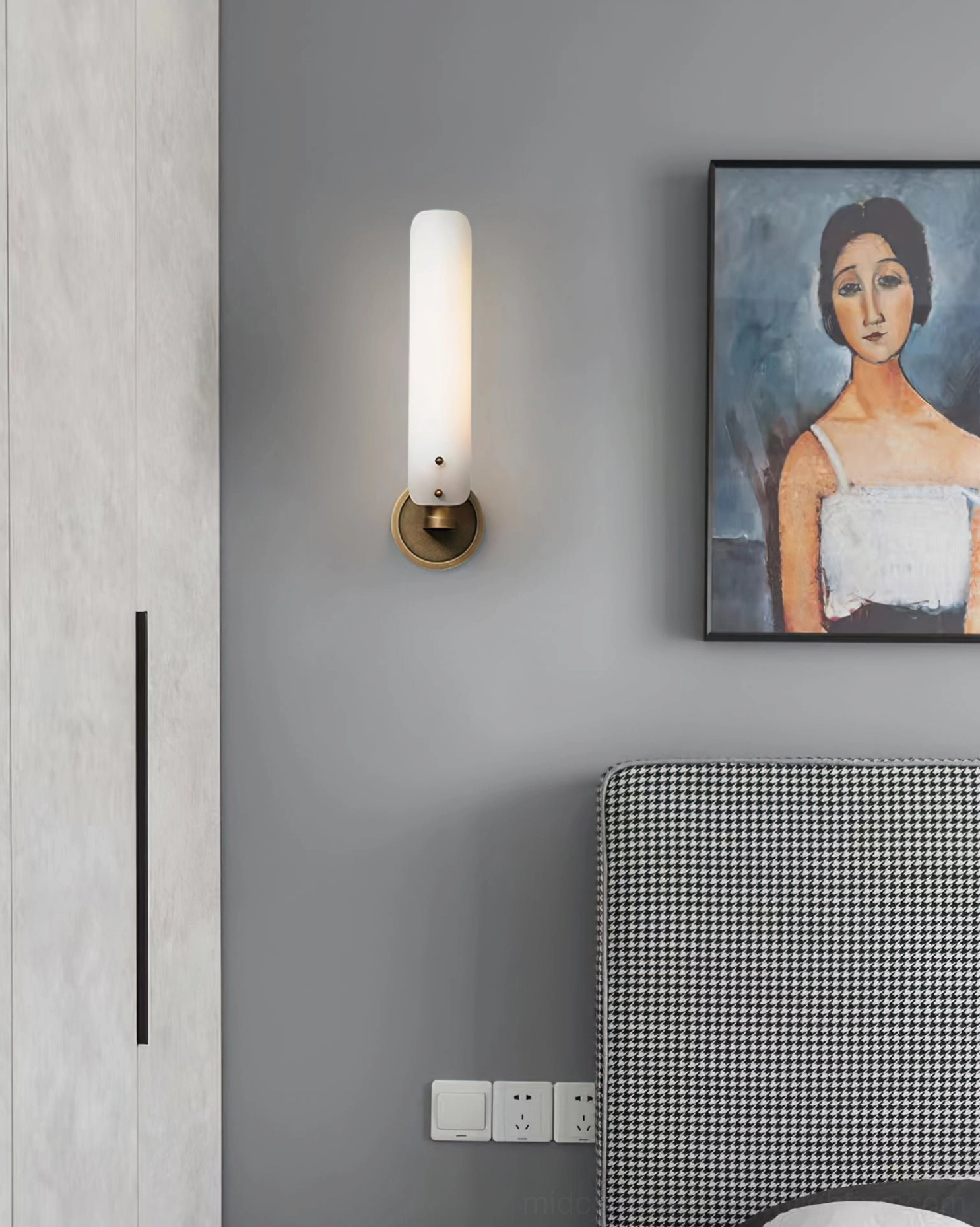 Single wall sconce in hallway or bedroom mounted beside decorative artwork and wall décor