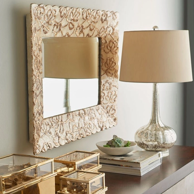 Clear ceramic glass table lamp with neutral fabric shade on luxury entryway console with carved mirror