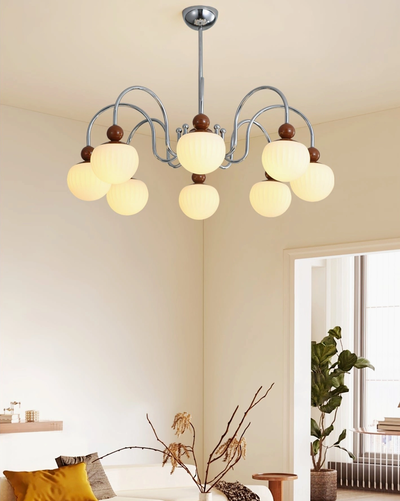 Warm-toned Notti 8-arm chandelier installed in cozy residential bedroom with neutral decor and glowing yellow lights