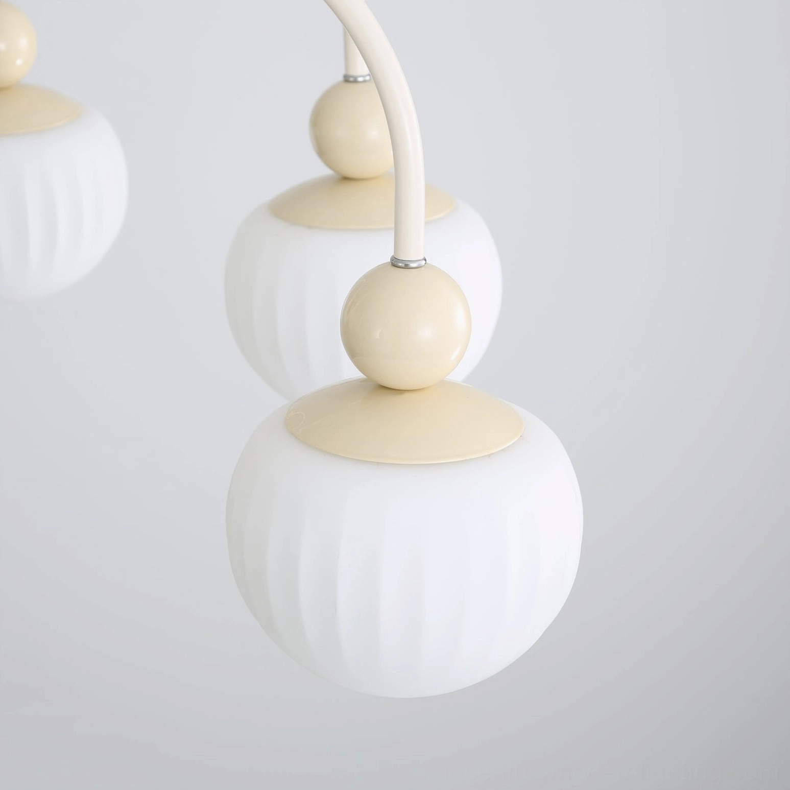 Detailed view of Notti chandelier ribbed frosted glass shade and cream metal joint connection point