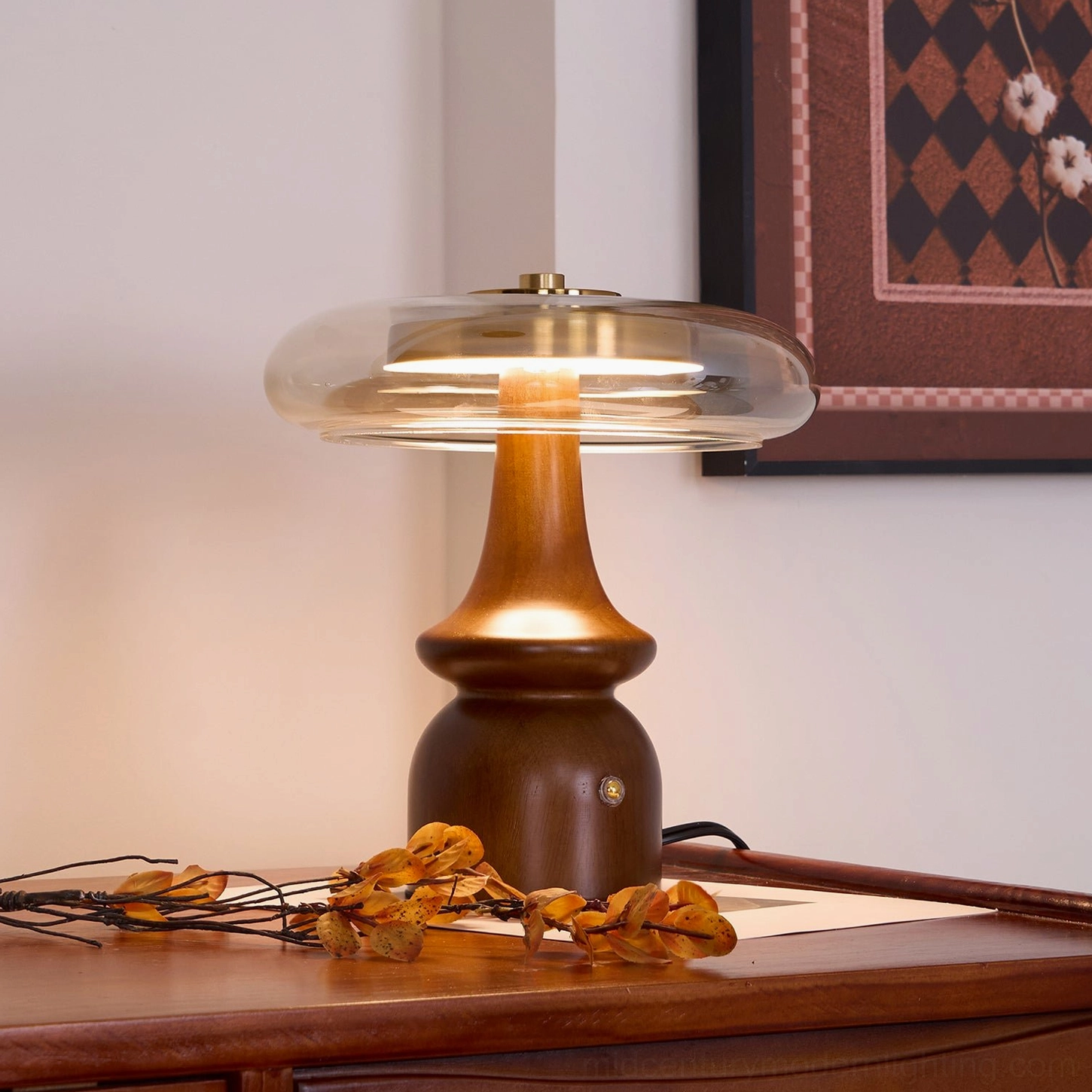 Nova table lamp illuminated with warm glow, high angle view on side table with framed wall art creating ambient lighting