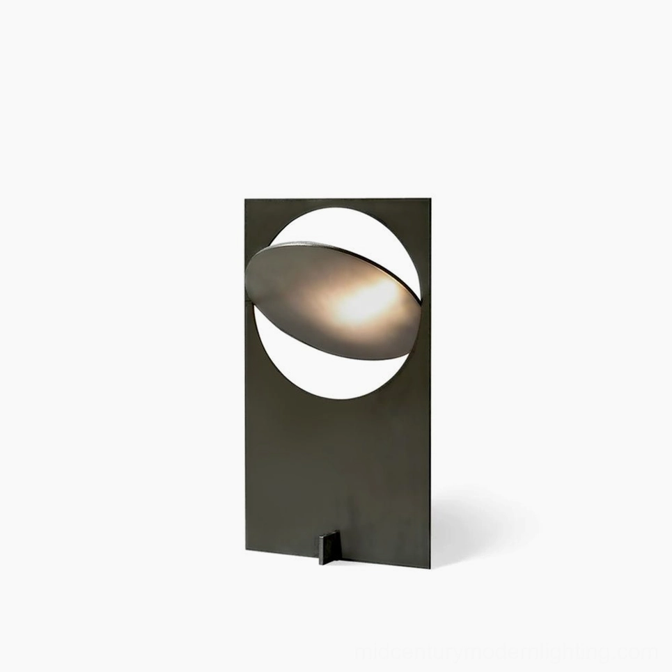 OBJ 01 minimalist table lamp with matte black metal finish and warm LED light, front view on white background, geometric crescent cutout design