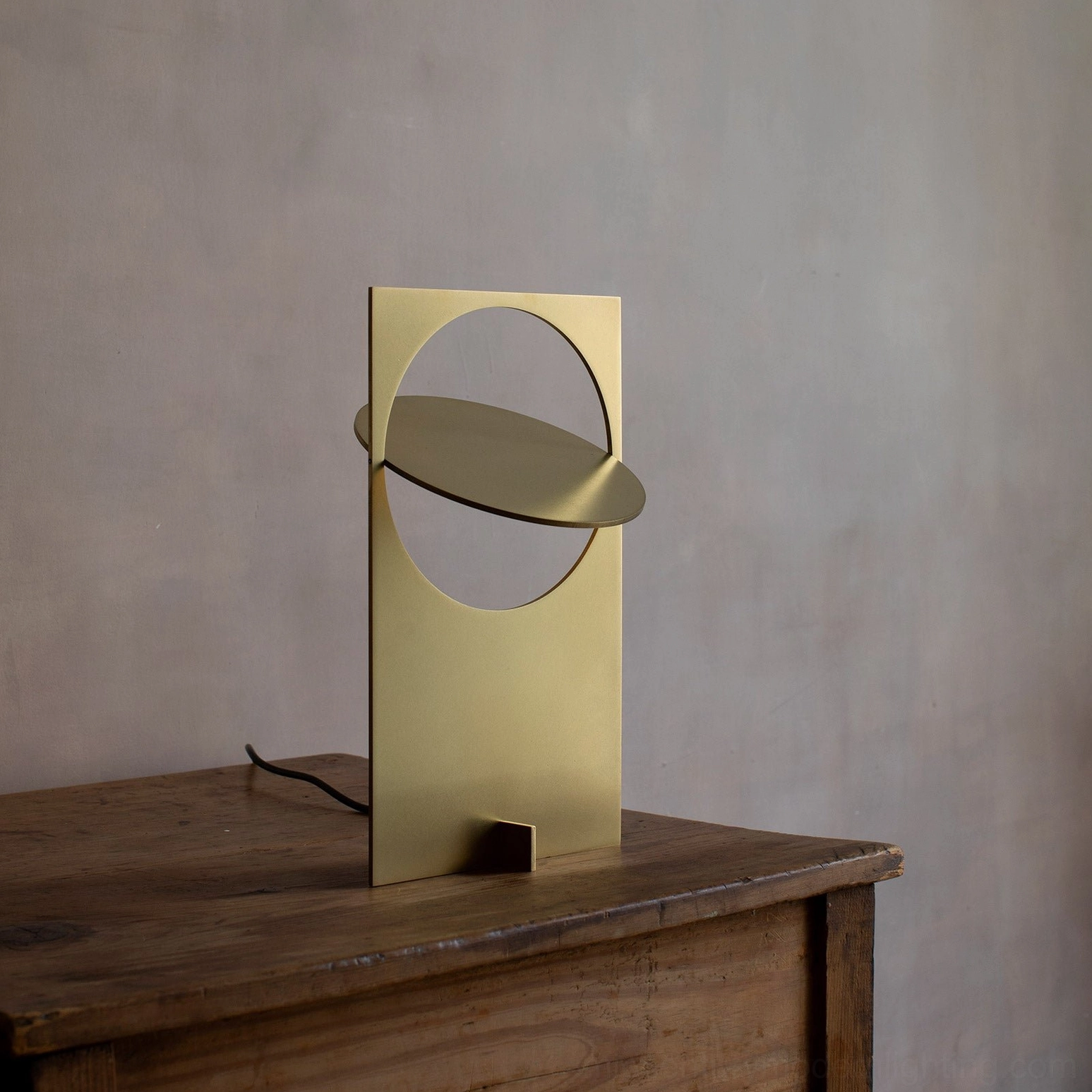 OBJ 01 copper metal table lamp on wooden side table, modern minimalist brass gold finish, lit with warm ambient light, sculptural design