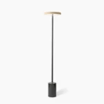Oblique modern floor lamp with minimalist black metal pole and marble base, studio shot on white background showing the lamp's elegant geometric silhouette