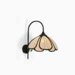 Okai floral wall sconce with black metal frame and abaca petal shade, side front view on white wall