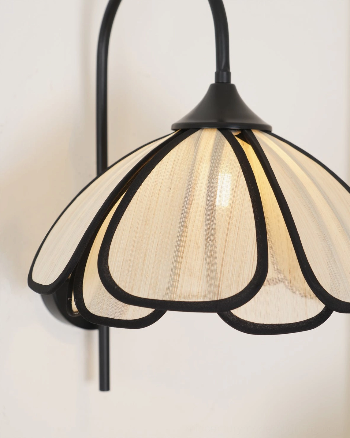 Close-up of Okai wall lamp shade showing layered petal design and black trim edging
