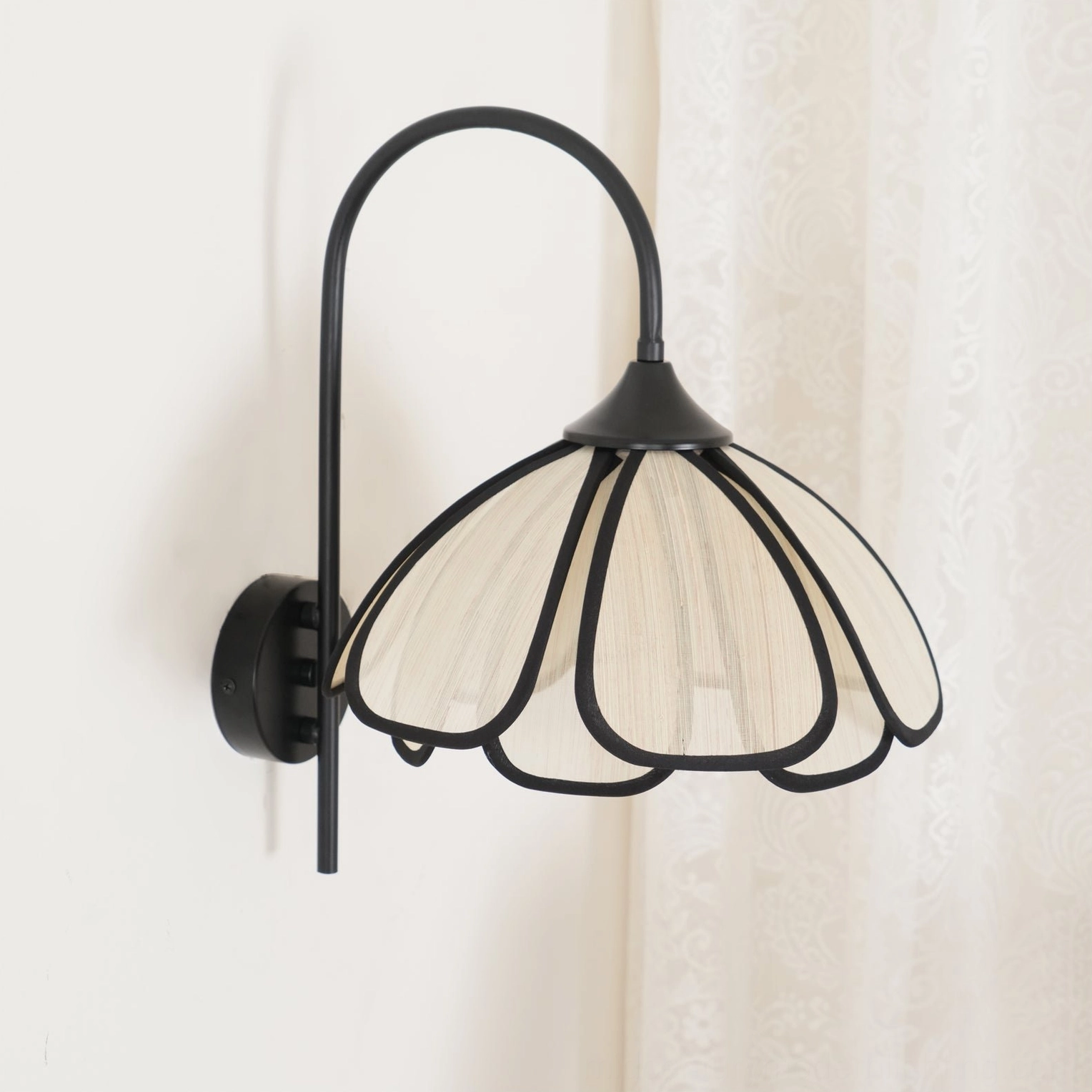 Front view of Okai symmetrical floral wall sconce with curved gooseneck arm design