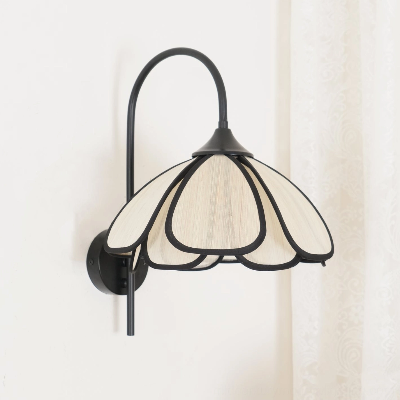 Mid-century modern wall sconce with curved gooseneck arm and fabric petal shade detail