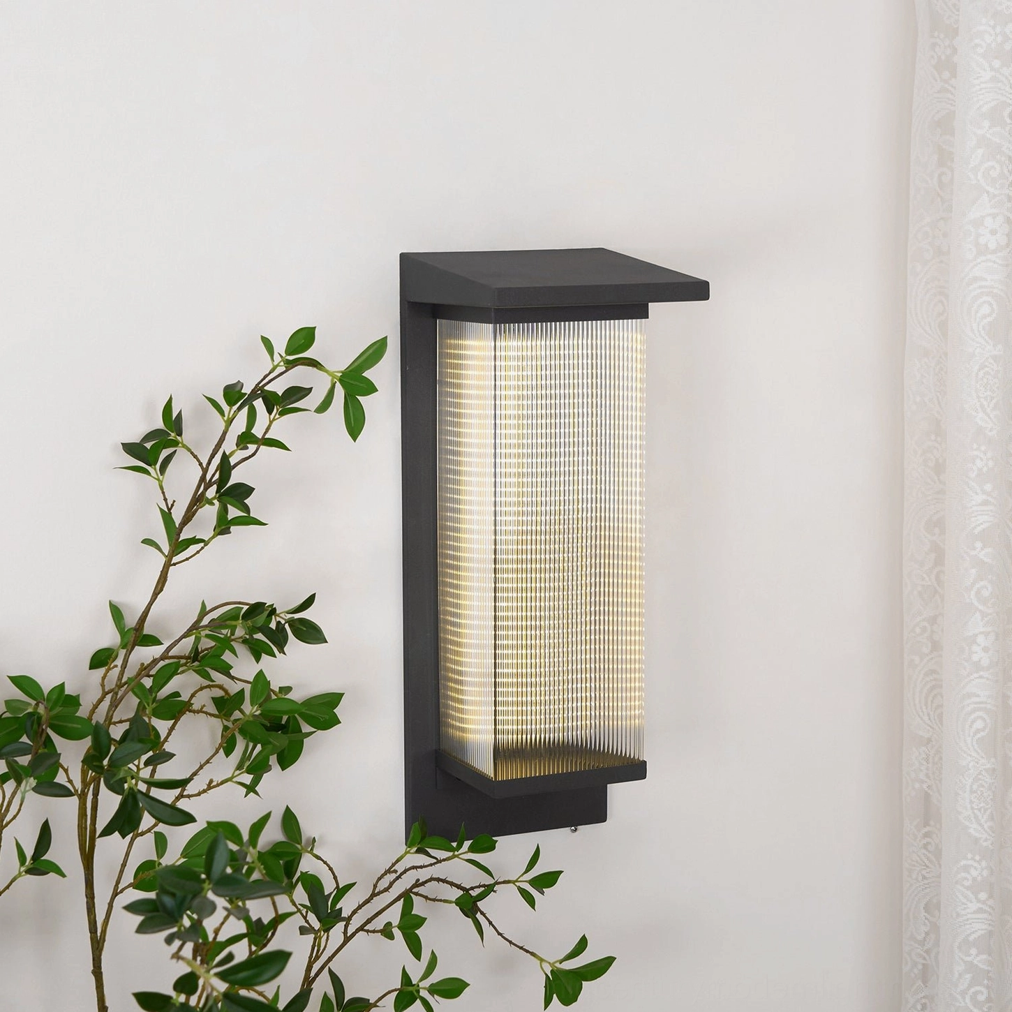 Oleron Box left angle lit view, warm ambient outdoor lighting, roof-shaped top trim detail, ribbed glass shade, mid-century modern fixture