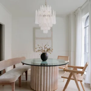 Ollie frosted teardrop chandelier installed in modern minimalist dining room with white walls and wooden table