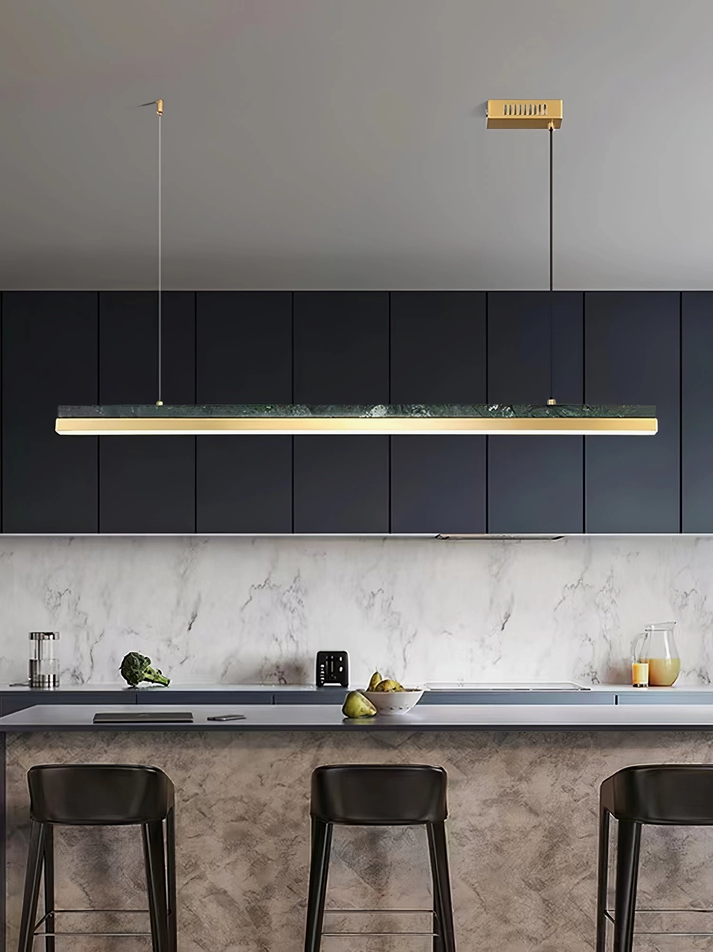 One Word pendant light illuminating dark modern kitchen bar with black cabinets and marble backsplash
