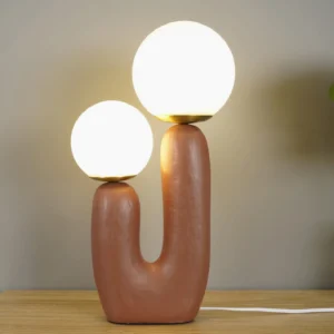 Oo table lamp illuminated on wooden tabletop with warm ambient lighting