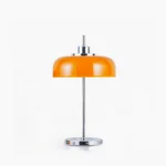 Mid-century modern orange dome table lamp with polished chrome base on white studio background - front view