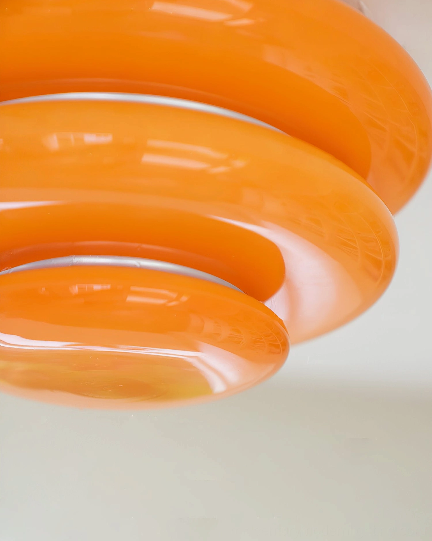 Close-up detail orange glass shades silver chrome separators mid-century light