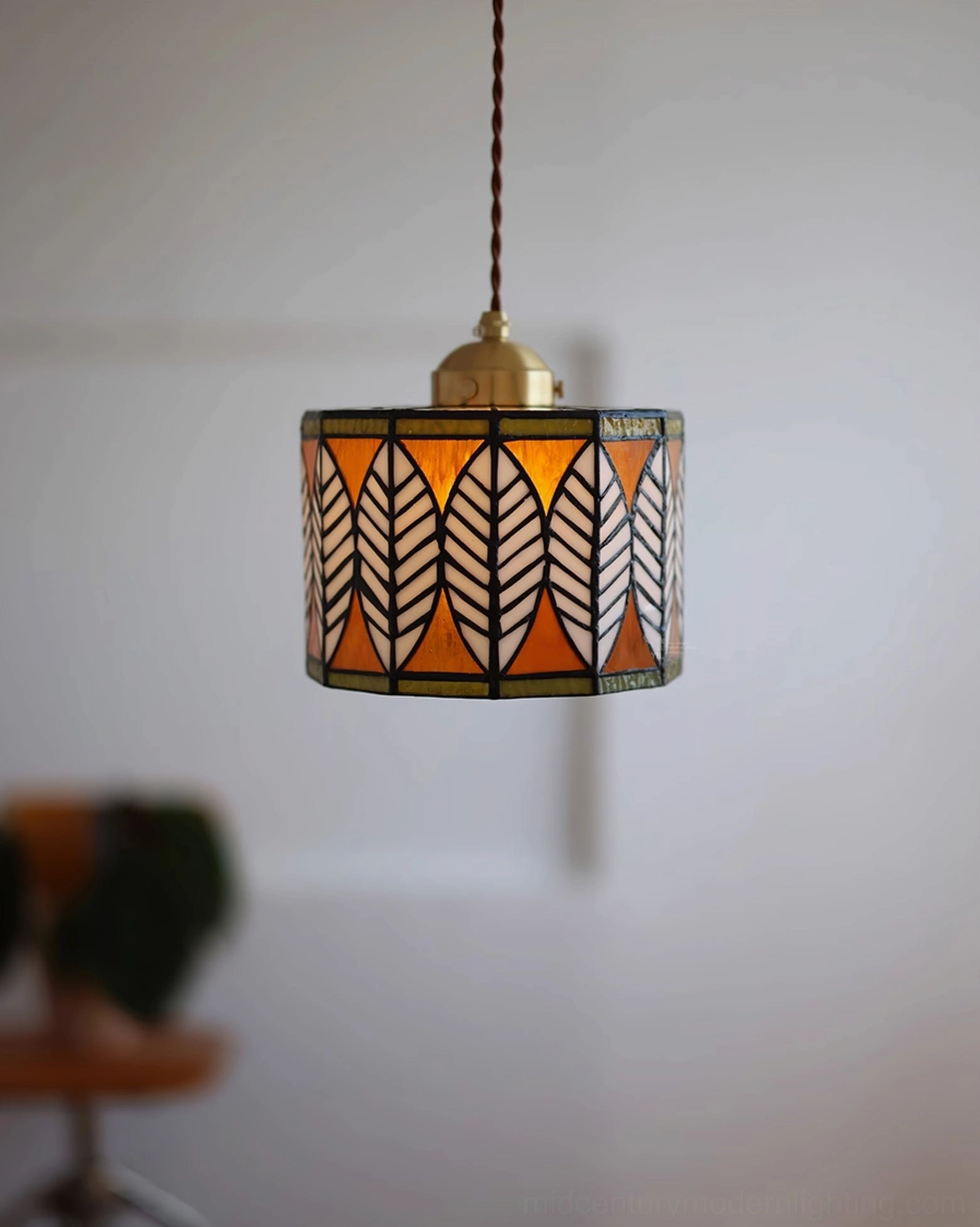 Orange-toned botanical leaf stained glass Tiffany pendant with brass fixture and braided cord