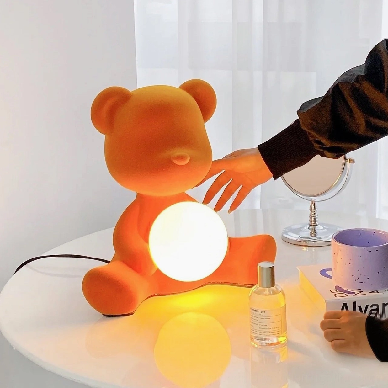 Orange teddy bear desk lamp on bedroom vanity with warm glowing light and modern minimalist decor