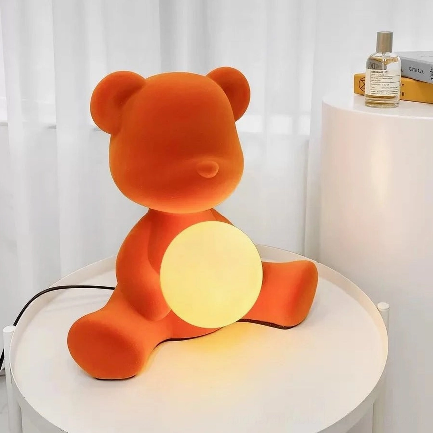 Orange flocked teddy table lamp on bedroom nightstand with warm ambient lighting