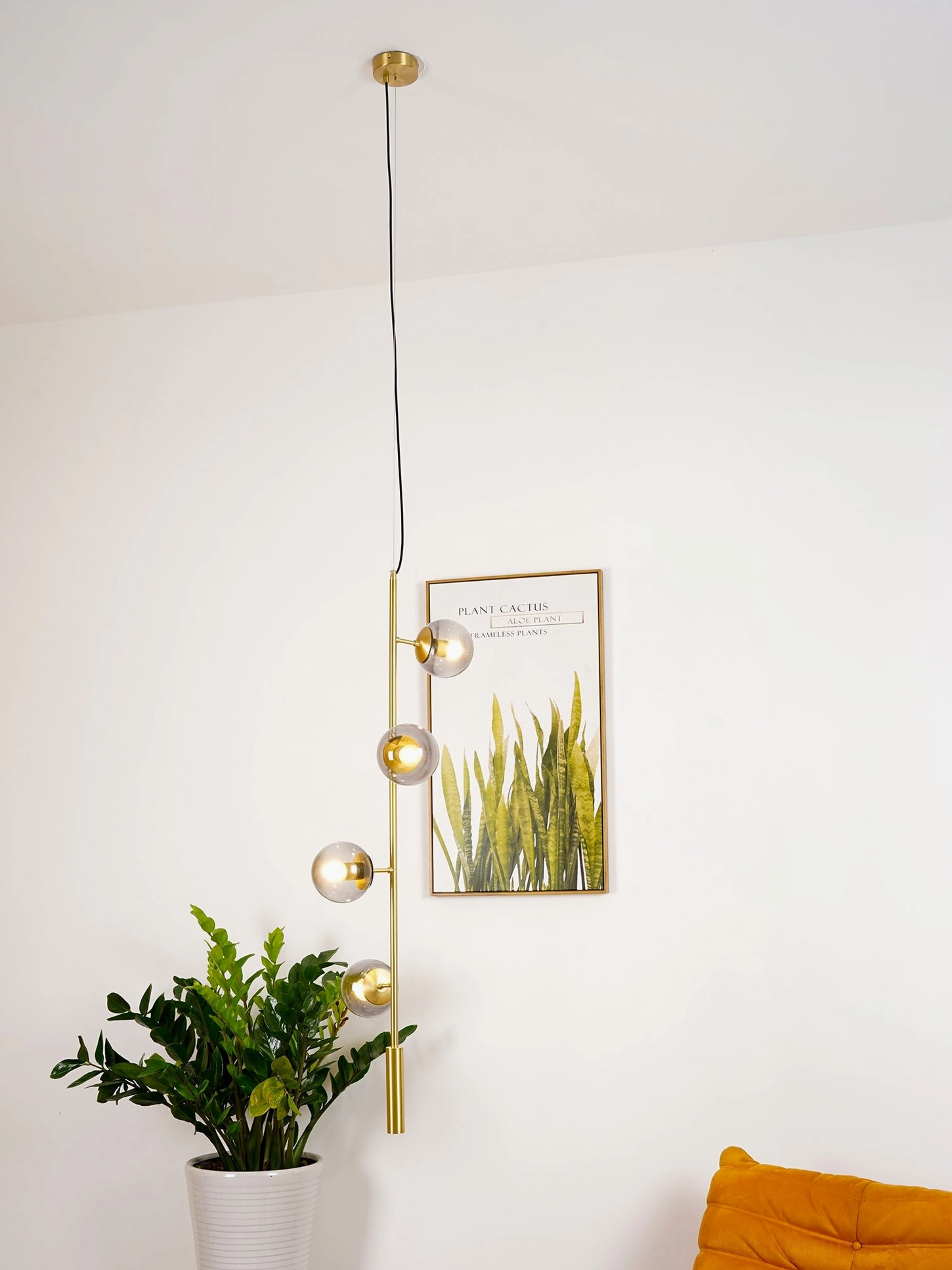 Blue glass orb pendant light with black metal rod in modern living space
