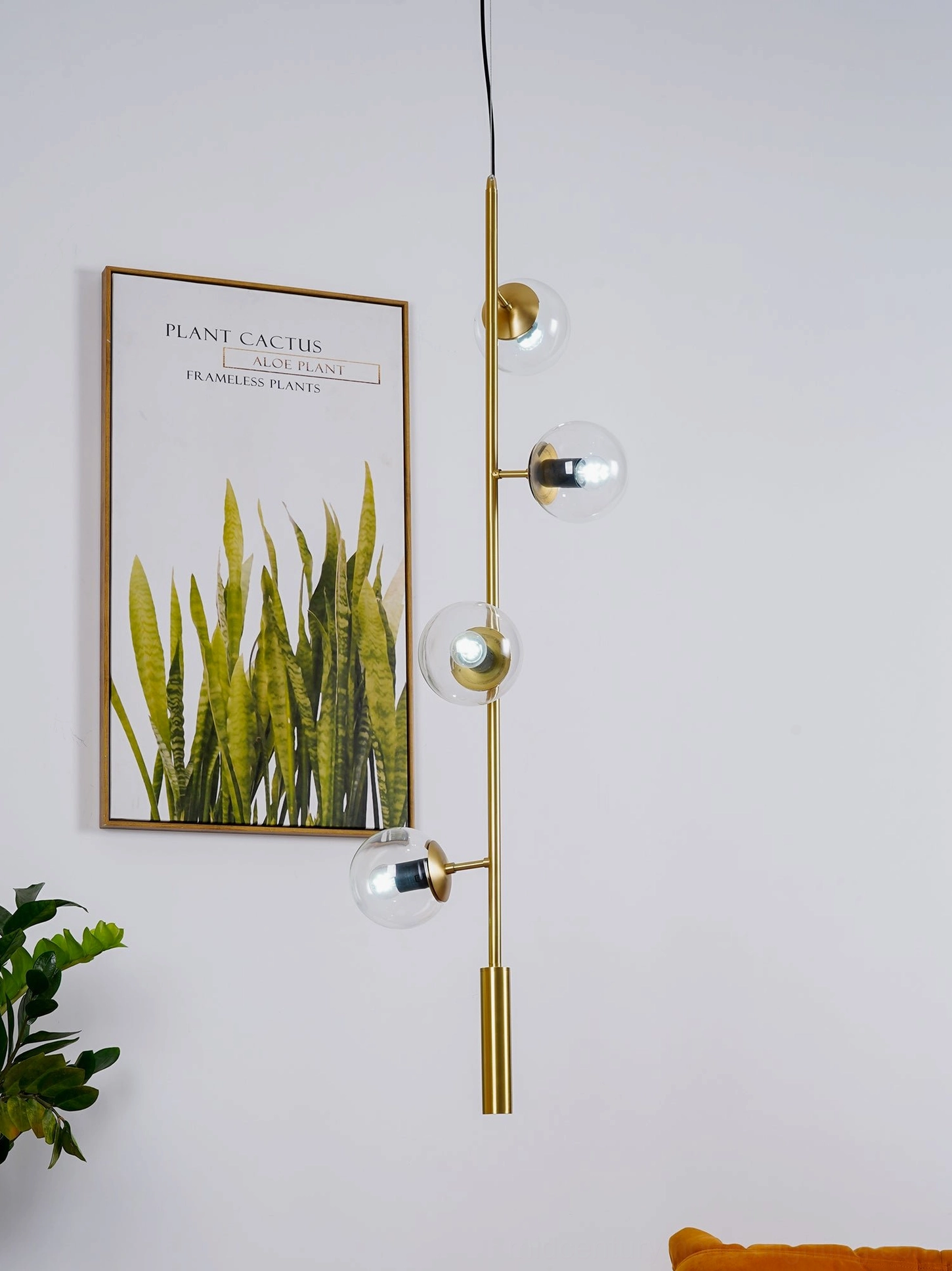 Orb pendant light in smoke grey glass with brass rod, artistic studio photography