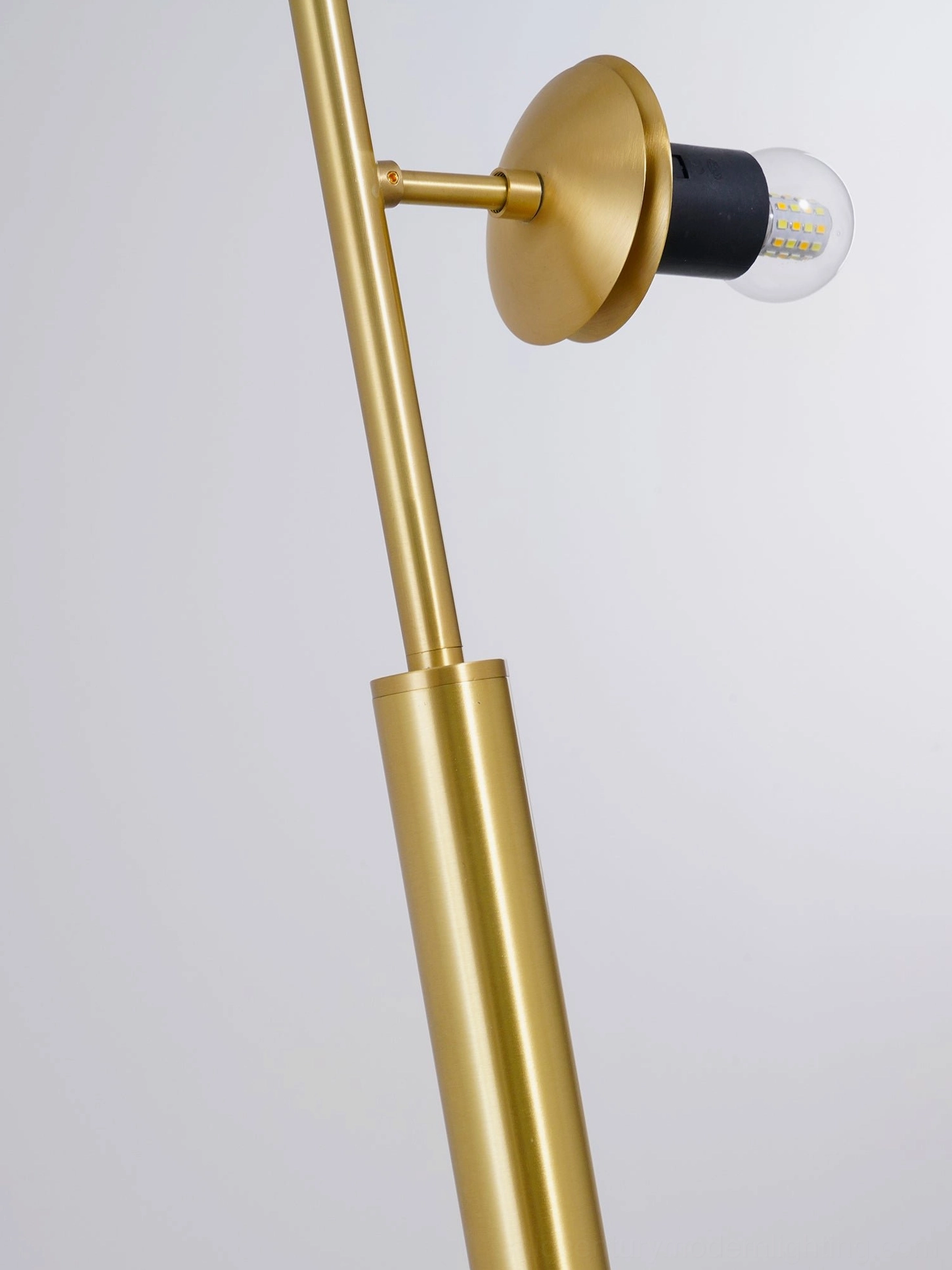 Close-up of orb pendant light socket showing polished brass and black lamp mount detail