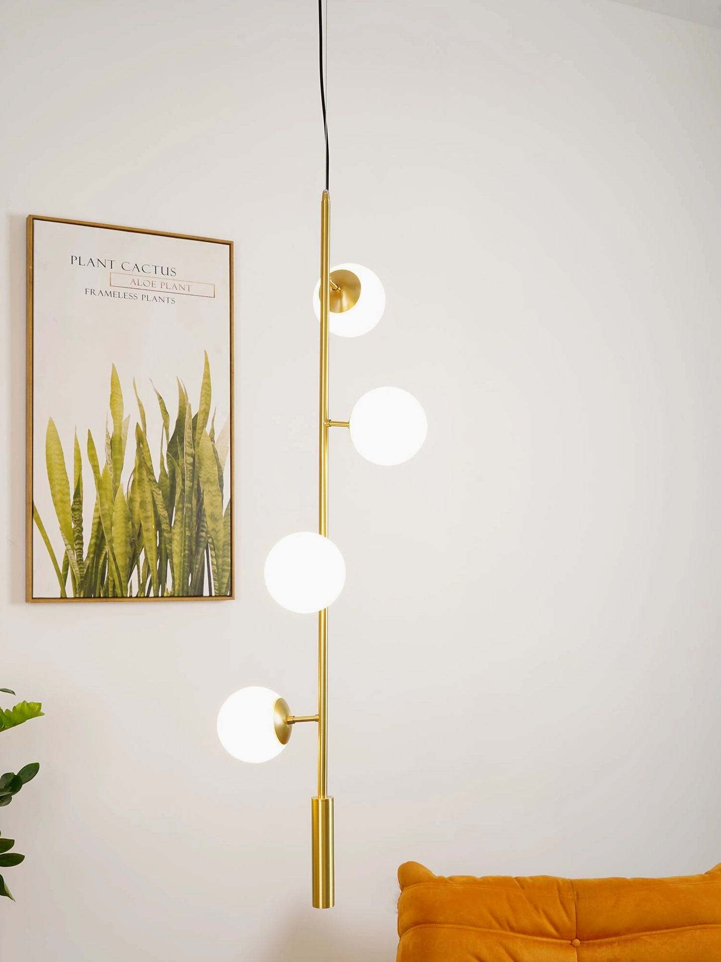 Vertical globe orb pendant light with warm brass finish in Nordic living room with wall art