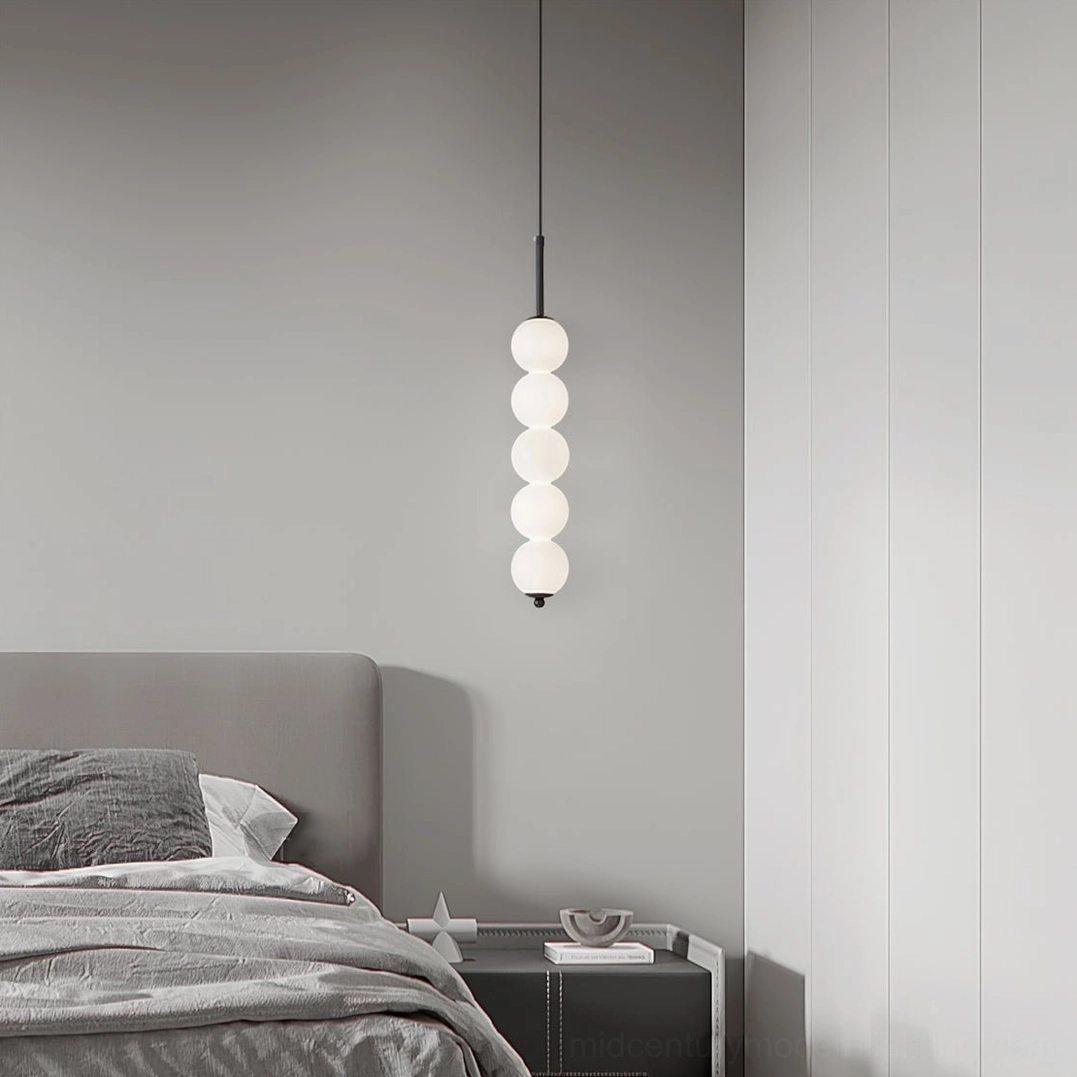 Five-orb Orbet milk glass pendant lamp frontal view in minimalist bedroom with dresser