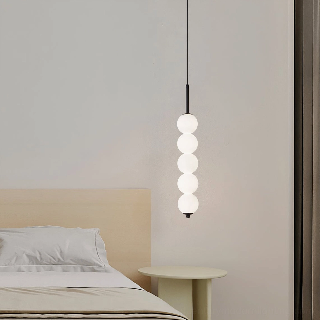 Five-orb Orbet pendant lamp with brass hardware in compact modern bedroom with white bedding