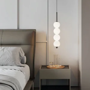 Four-orb Orbet pendant lamp installed in modern minimalist bedroom above nightstand