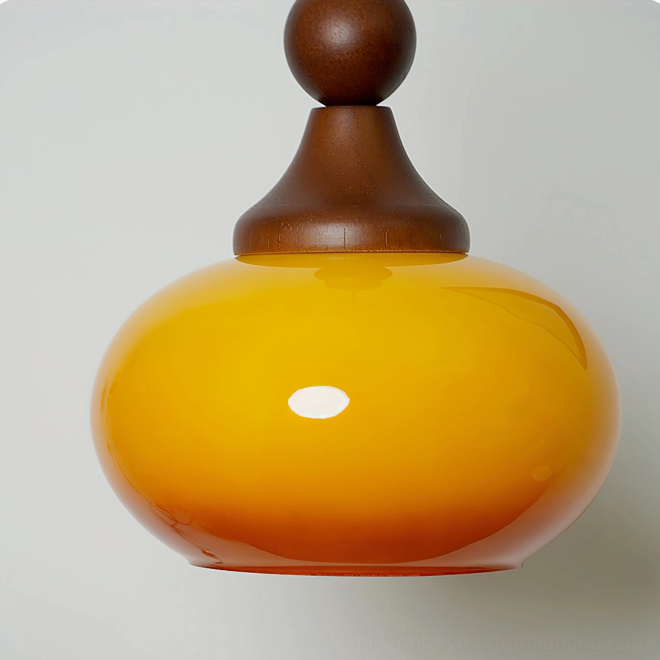 Detailed view of Orbique amber glass shade showing glossy gradient finish and warm orange luminescence