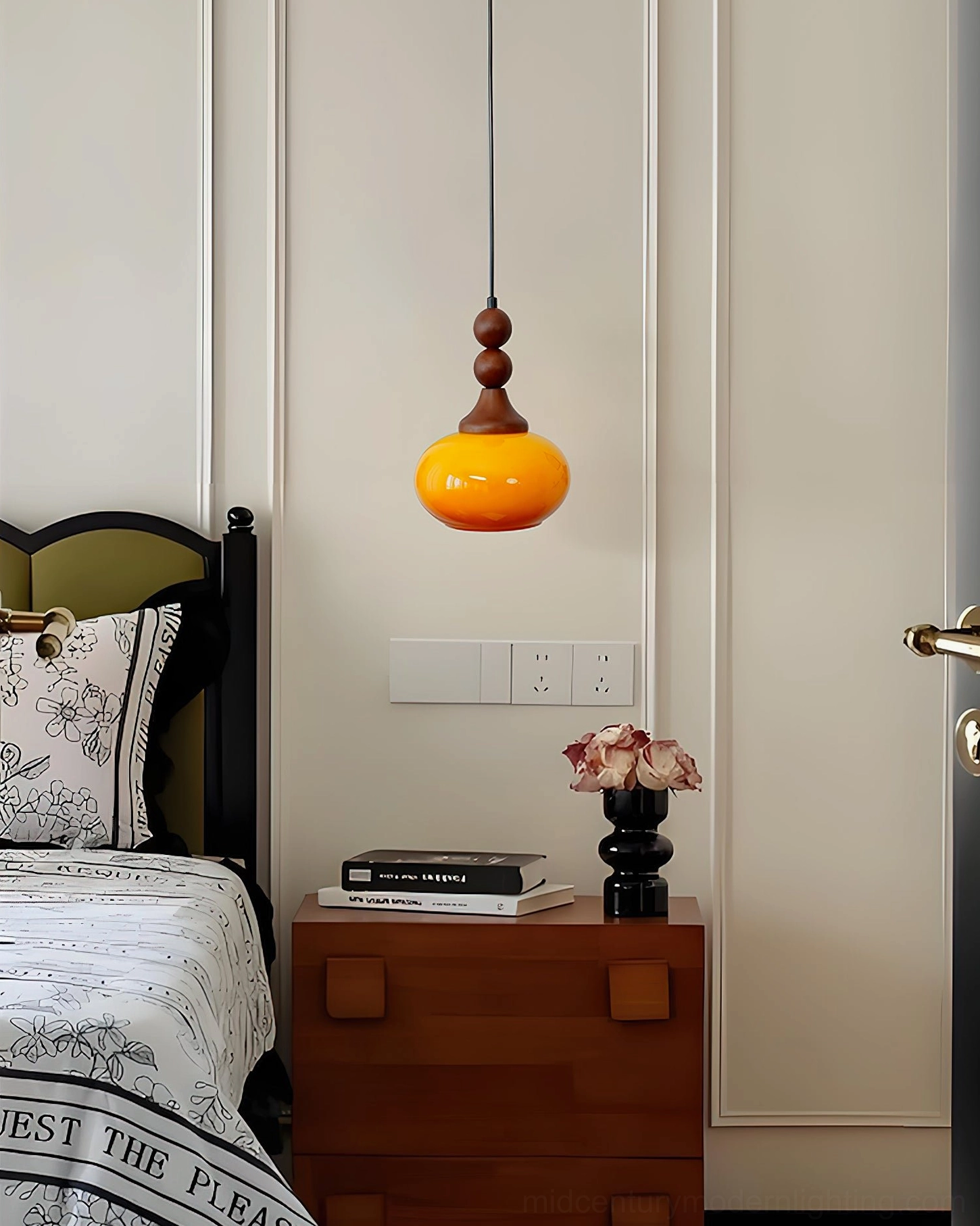 Orbique amber pendant light in retro American bedroom with patterned bedding and wooden nightstand
