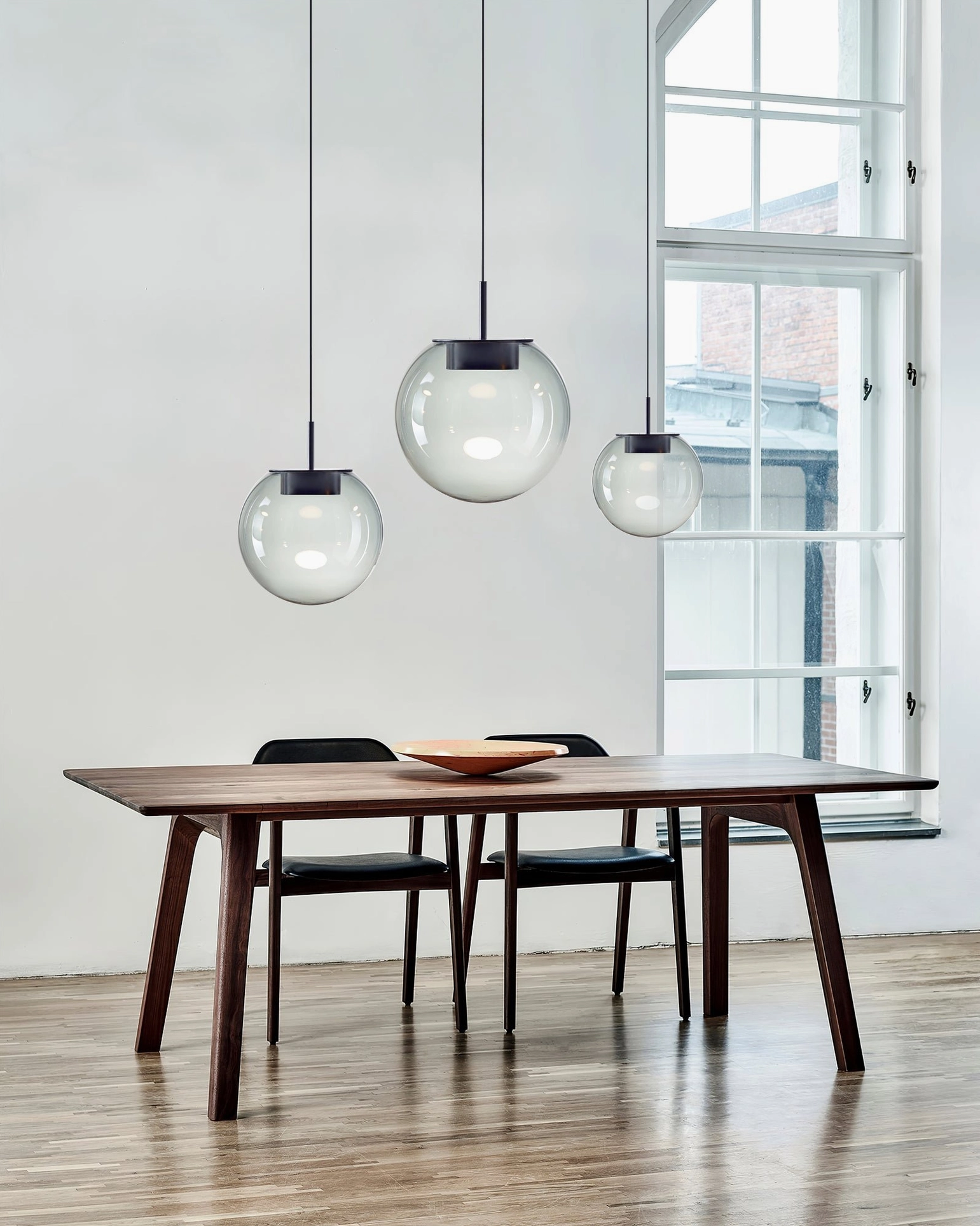 Orbis pendant lamps above wooden dining table - contemporary residential dining room with handblown glass spheres