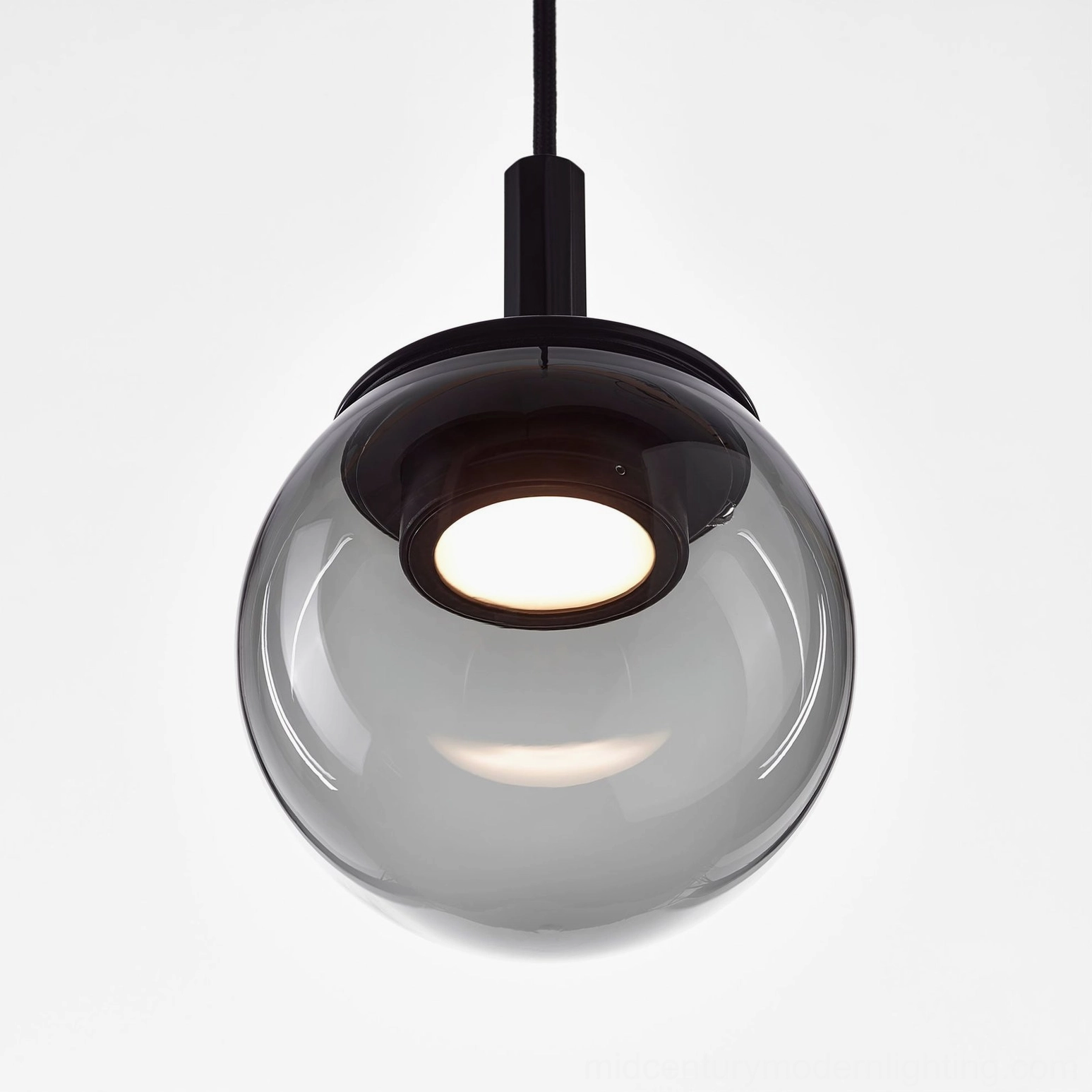 Orbis pendant studio display - handblown glass sphere with metal fixture against neutral backdrop
