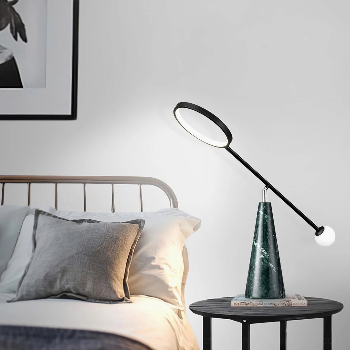 Modern Orbit table lamp in bedroom setting beside wall art and bed, ambient evening lighting