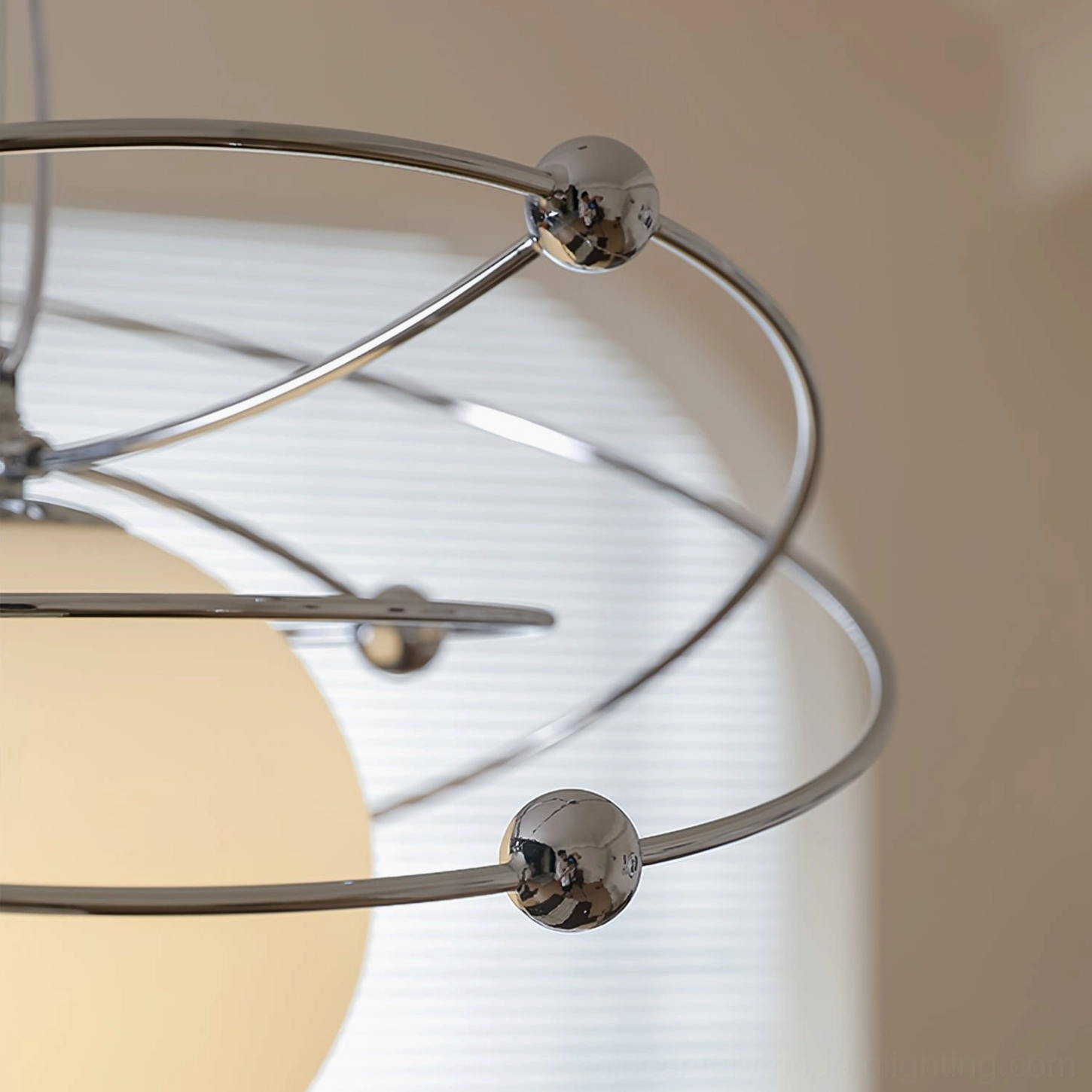 Side close-up view of interlocking chrome orbital structure of space-age pendant fixture