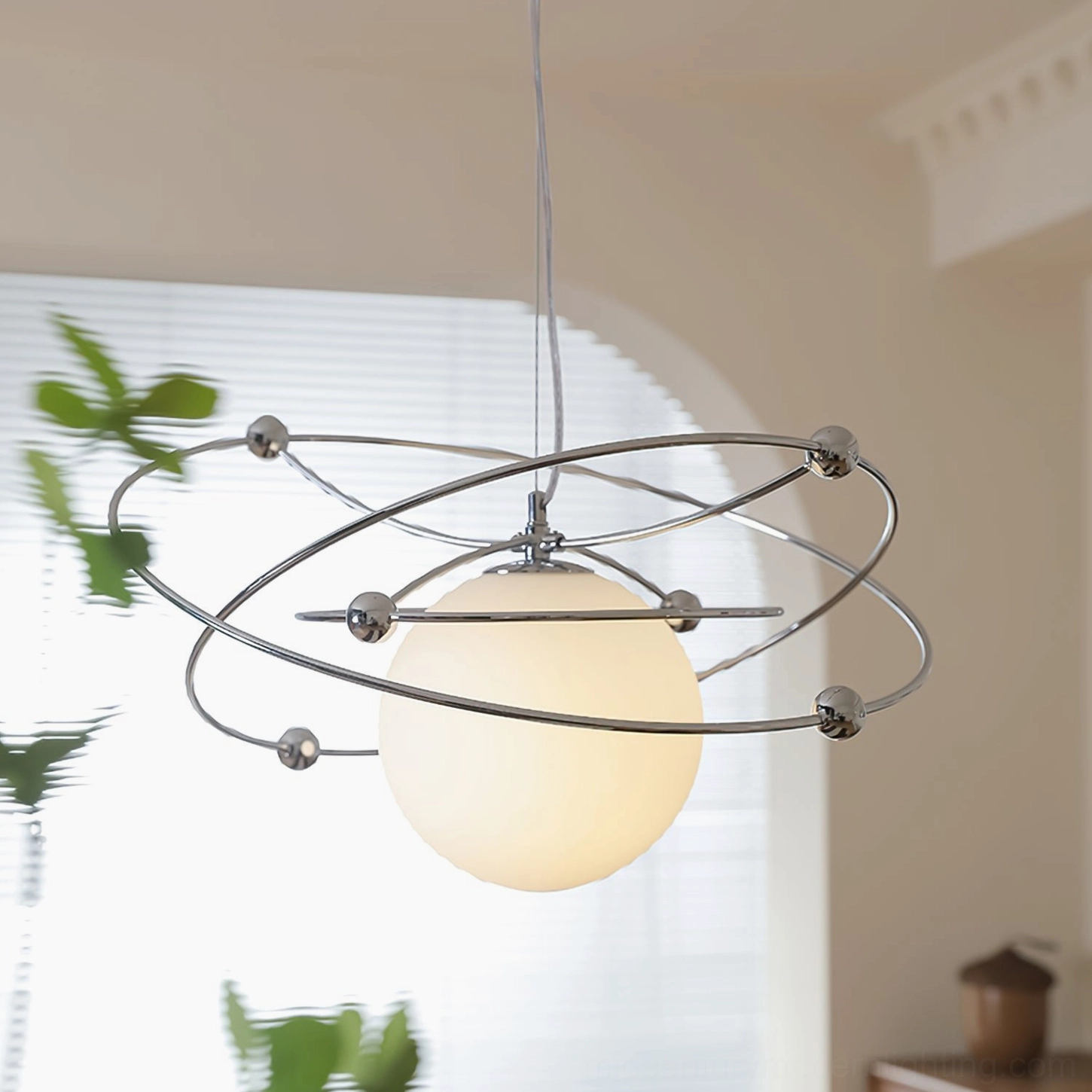 Mid-century modern orbital pendant lamp in cream dining room with natural light and window blinds